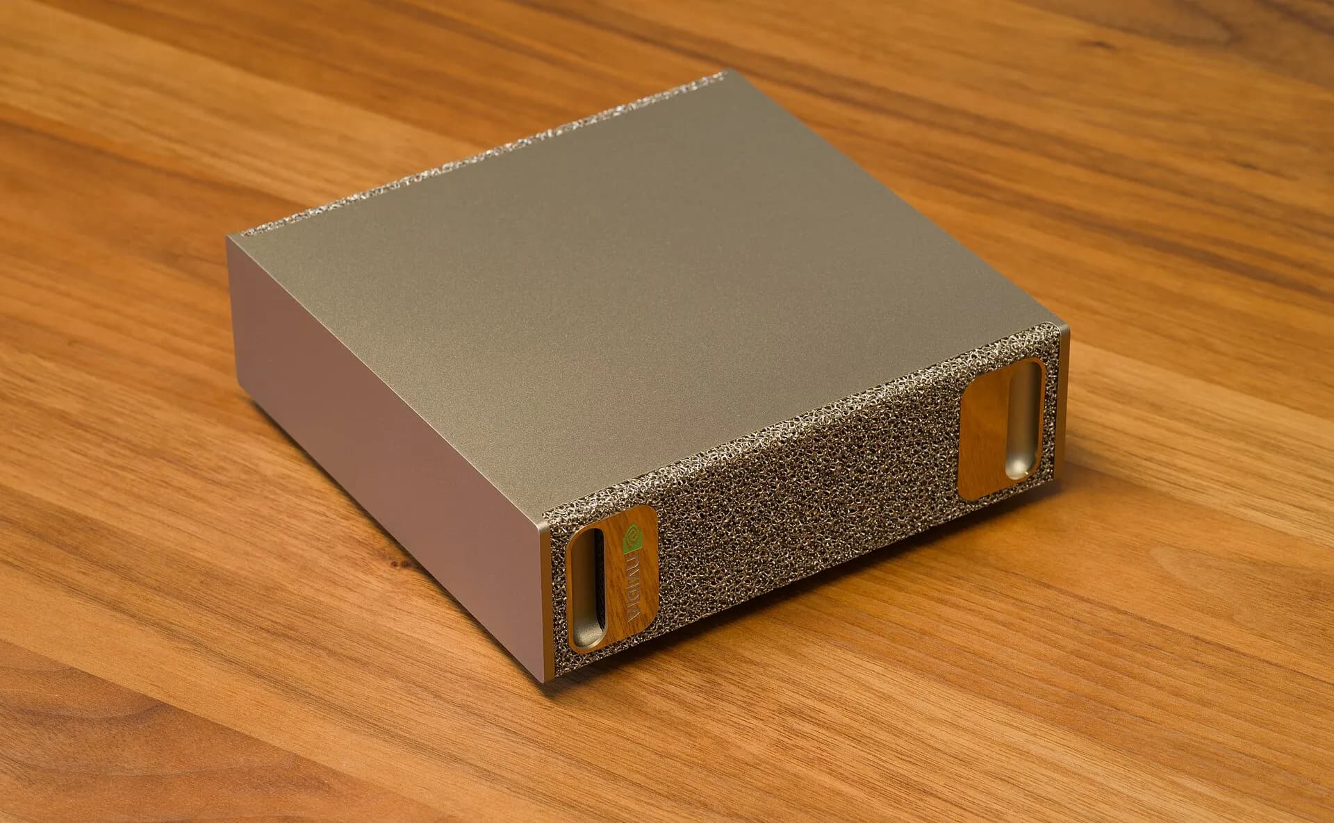 A compact NVIDIA DGX Spark AI computer on a wooden desk