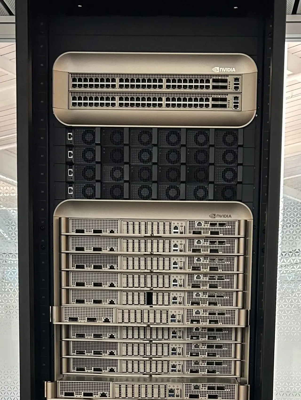 An NVIDIA GB200 liquid-cooled AI server rack with gold-finished compute trays
